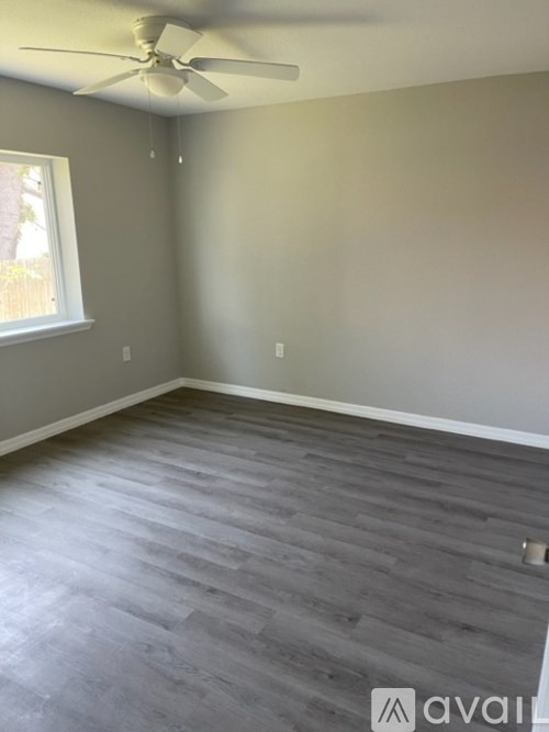 A room with a ceiling fan and a window.