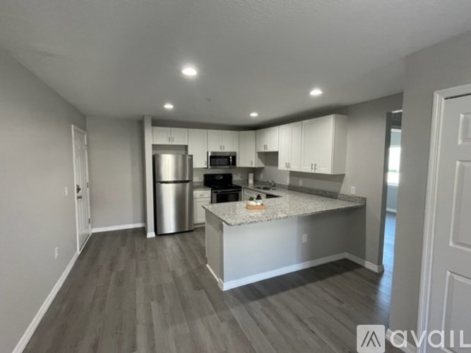 A kitchen with a stainless steel refrigerator, microwave, and oven.
