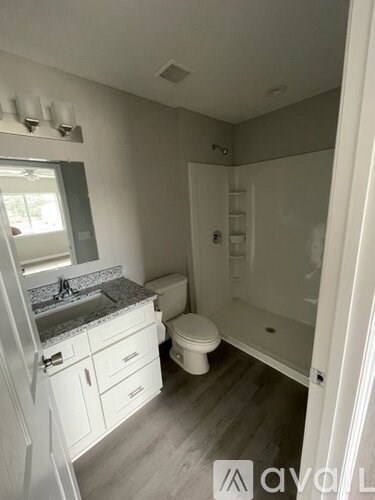 A bathroom with a toilet, sink, and shower.
