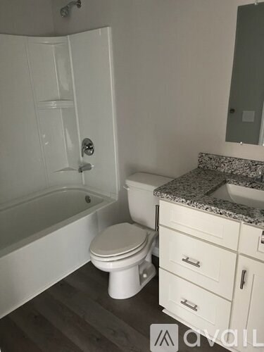 A white toilet sits next to a bathtub in a bathroom.