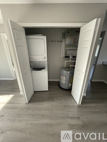 A kitchen with a white fridge and a white door open.