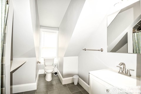 A white bathroom with a toilet, sink, and bathtub.