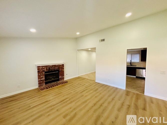 A room with a fireplace and wooden flooring.