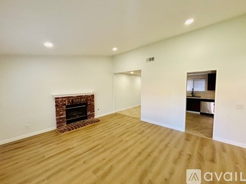 A room with a fireplace and wooden flooring.