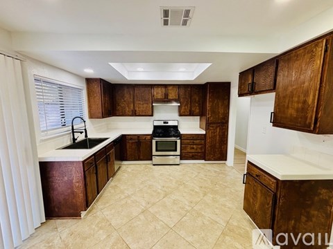 A kitchen with brown cabinets and a white countertop.