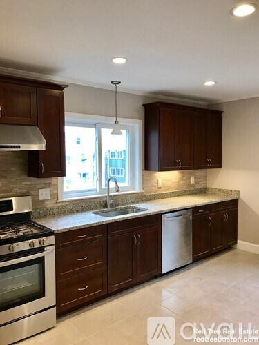 A kitchen with brown cabinets and a stainless steel oven.