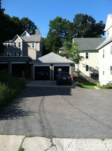A car is parked in a driveway in front of a house.