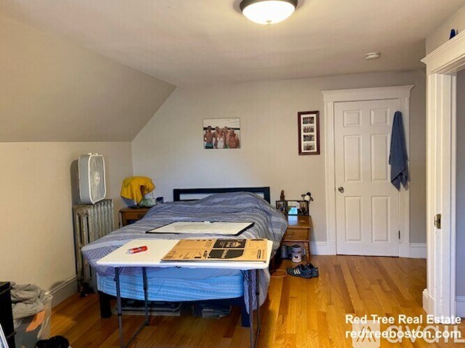 A bedroom with a bed, a nightstand, and a dresser.