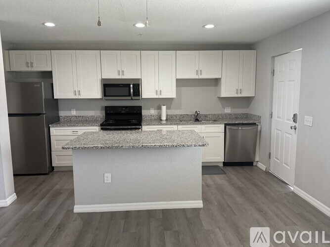 A kitchen with white cabinets and a granite countertop.