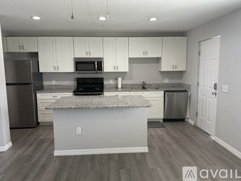 A kitchen with white cabinets and a granite countertop.