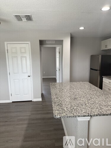 A kitchen with a granite countertop and a refrigerator.