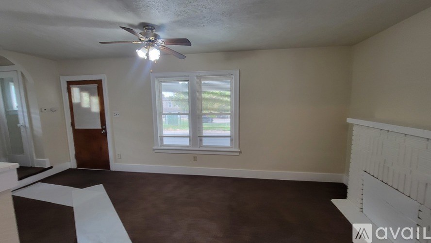 A room with a ceiling fan and a window.