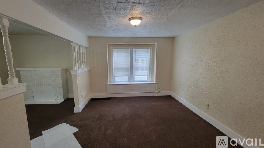 A room with a carpeted floor and a window.