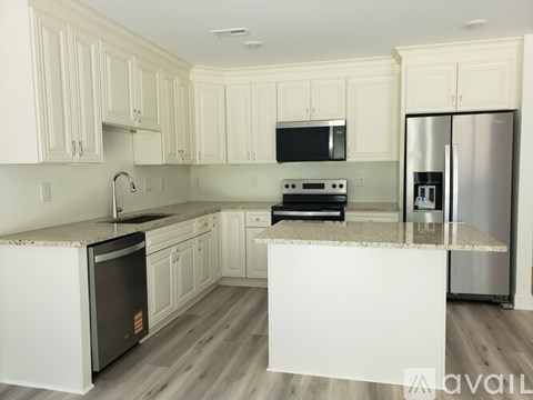A kitchen with white cabinets and a granite countertop.