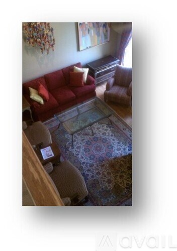 A living room with a red couch and a glass coffee table.