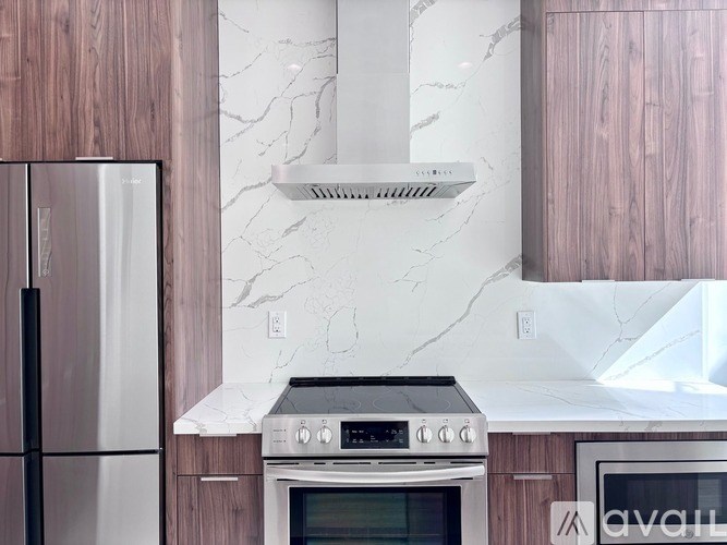 A modern kitchen with a stove and a refrigerator.