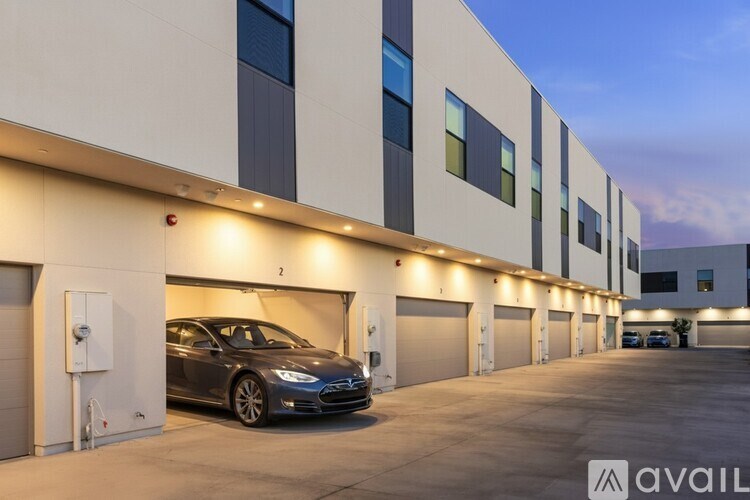 A car is parked in a garage in front of a building with the logo "avaiL" on the bottom right.