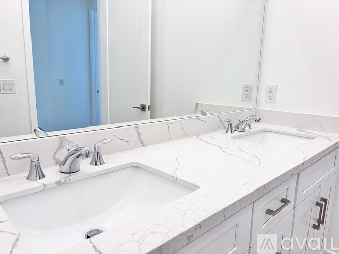 A bathroom with a white sink and marble countertop.