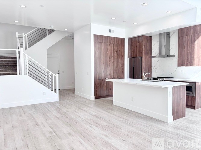 A modern kitchen with a white countertop and wooden cabinets.