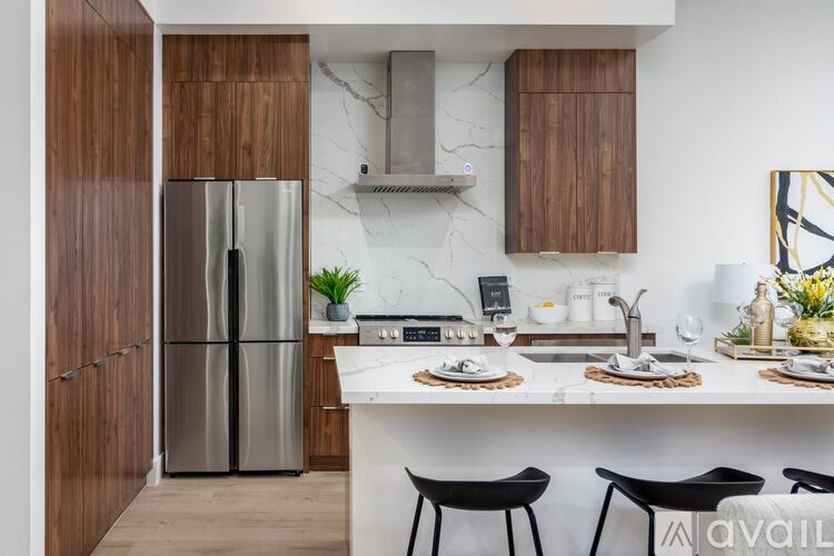 A modern kitchen with a stainless steel refrigerator and wooden cabinets.