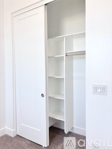 A white door with a shelf is open.