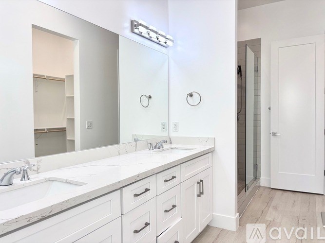 A bathroom with a white vanity and a mirror above it.