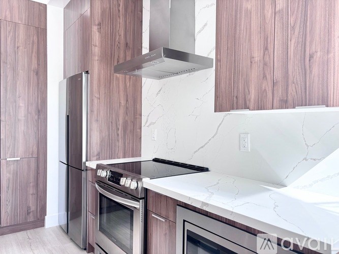 A modern kitchen with a stainless steel oven and wooden cabinets.
