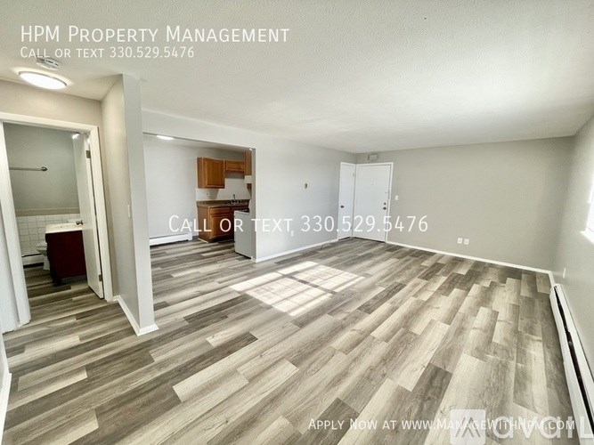 A room with wooden flooring and a sign for HPM Property Management.