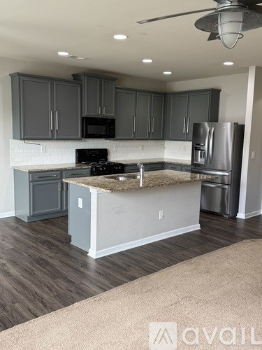 A kitchen with a stove, refrigerator, and cabinets.