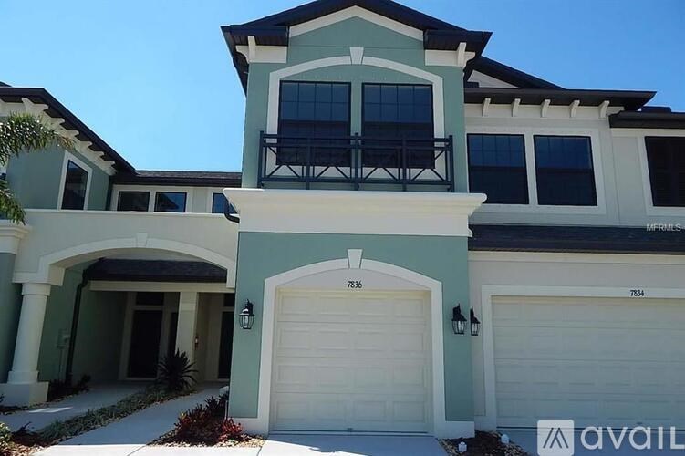 A two-story house with a balcony on the second floor.