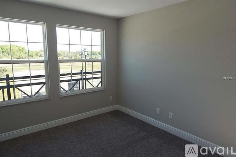 A room with two windows overlooking a bridge.