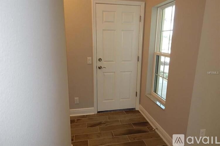 A white door is in a room with a window to the right.