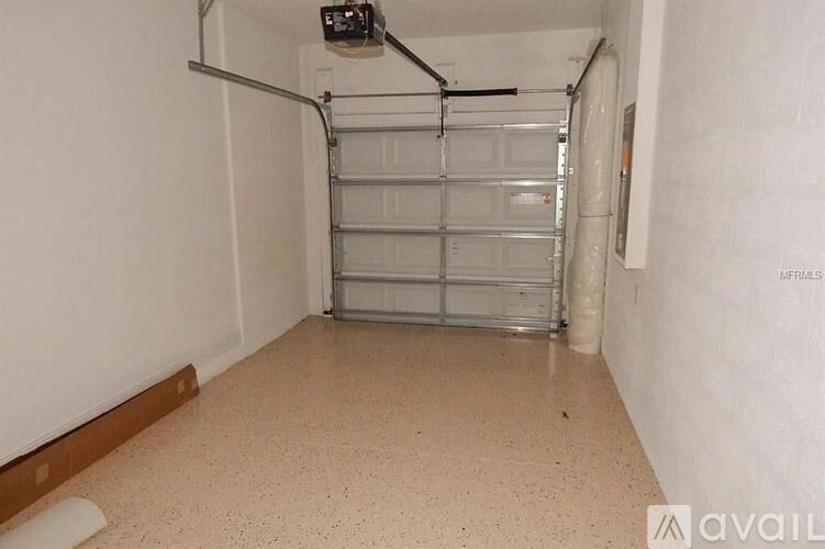 A garage door is closed and there is a pipe on the wall.