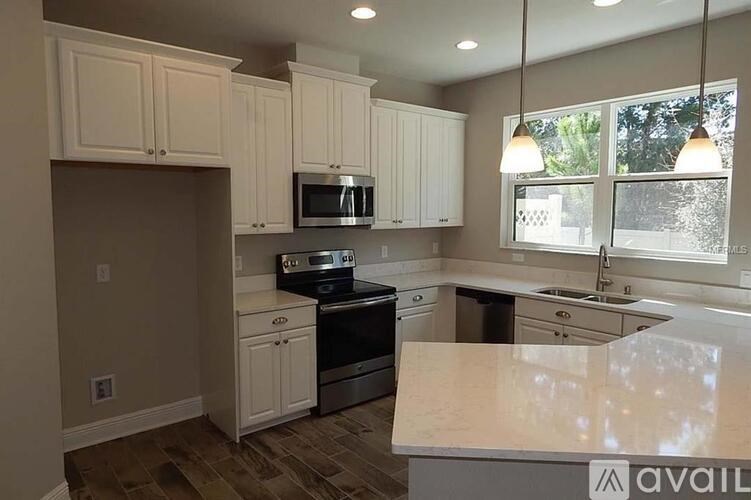 A kitchen with white cabinets and a granite countertop.