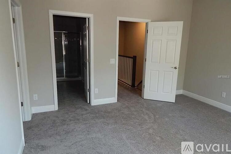 A room with a carpeted floor and two doors, one of which is open.