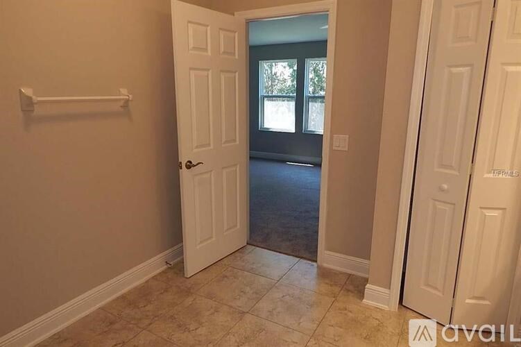 A hallway with a white door leading to a balcony.