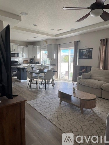 A living room with a television on a stand and a couch.