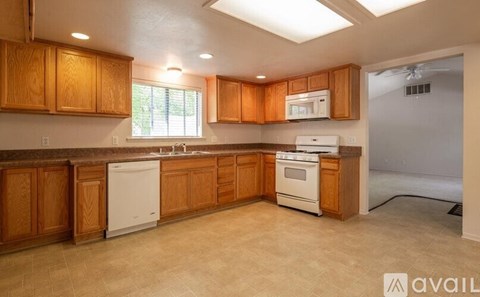 A kitchen with wooden cabinets and white appliances.