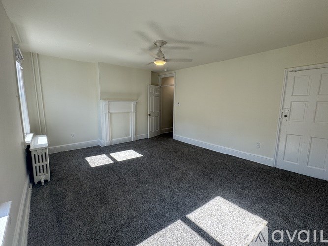 A room with a ceiling fan and carpeted floor.