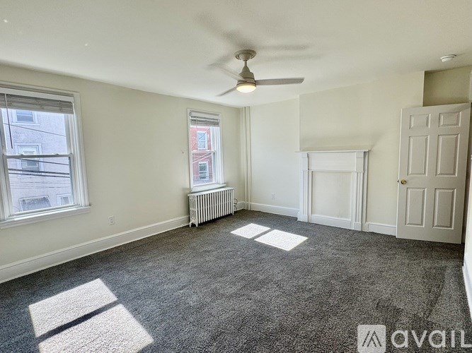 A room with a ceiling fan and a window with blinds.