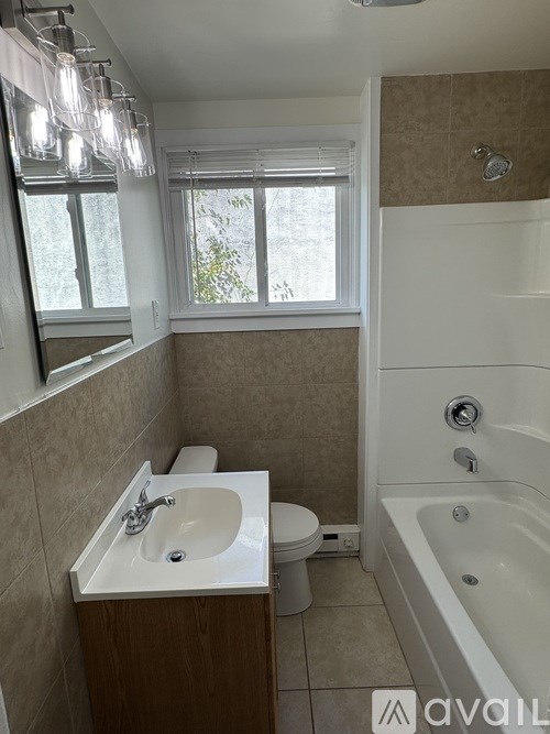 A bathroom with a tub, toilet, and sink.