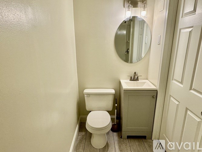 A white toilet sits next to a sink in a small bathroom.