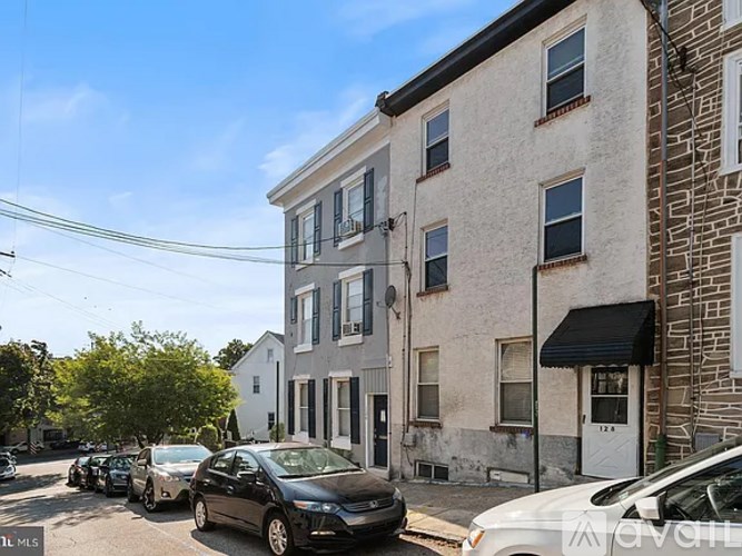 A row of parked cars on a street in front of a building.