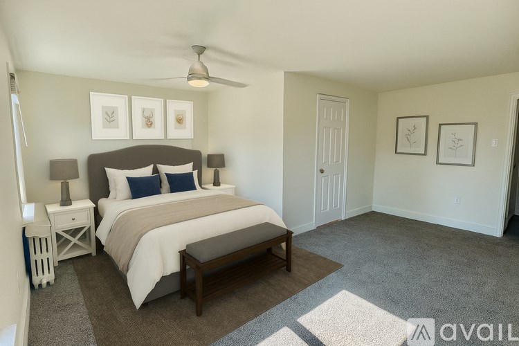 A bedroom with a bed, nightstand, and a bench.