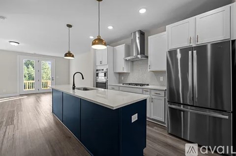 A modern kitchen with dark blue cabinets and stainless steel appliances.
