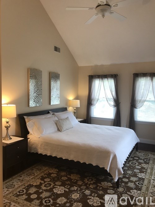 A bedroom with a large bed and a ceiling fan.