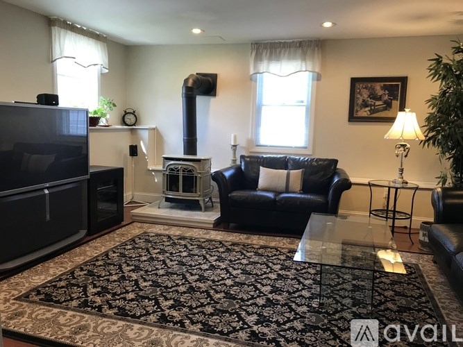 A living room with a black couch, a fireplace, and a television.