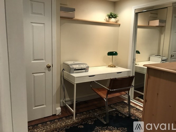 A white desk with a printer and chair in a room.