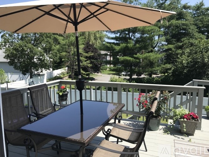A patio with a table and chairs under an umbrella.