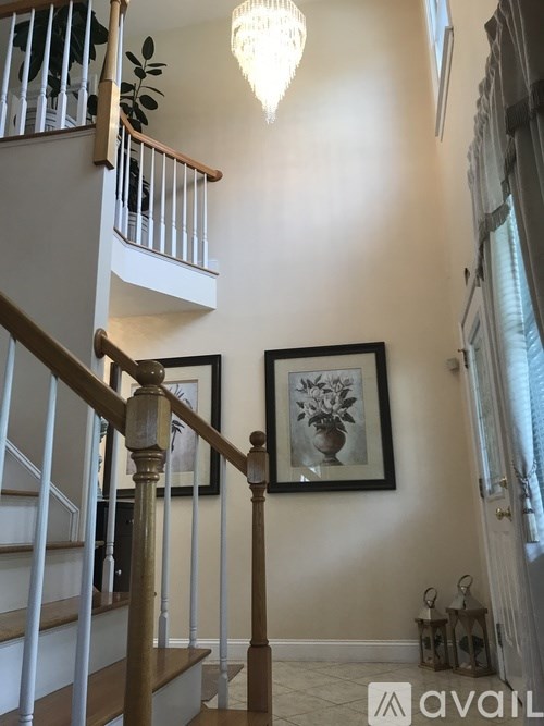 A staircase with a chandelier hanging from the ceiling.